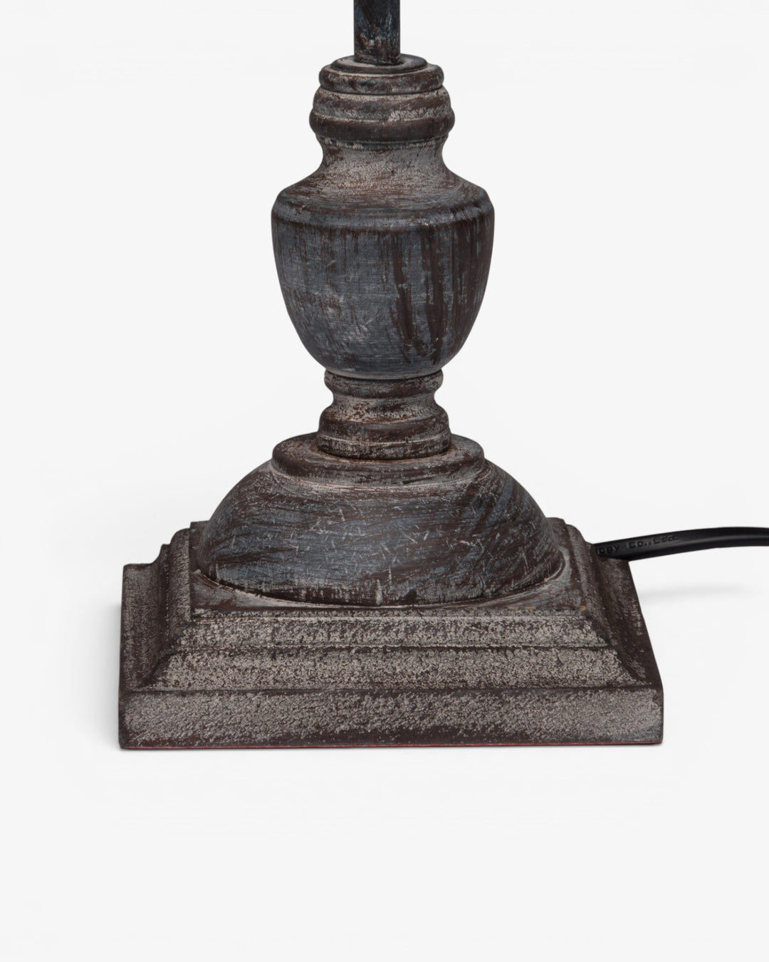 Decorative lamp base with intricate design on a white background