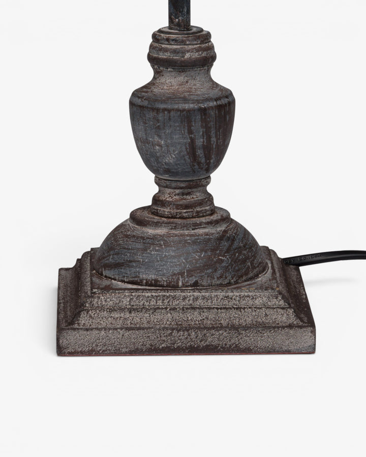Decorative lamp base with intricate design on a white background
