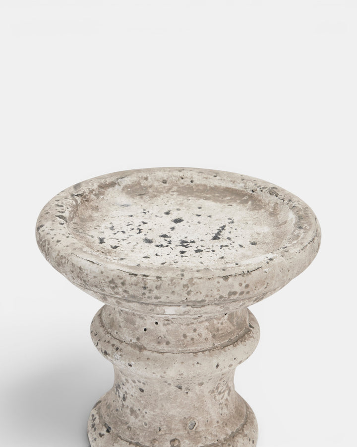 Beige candle holder with textured surface on a white background
