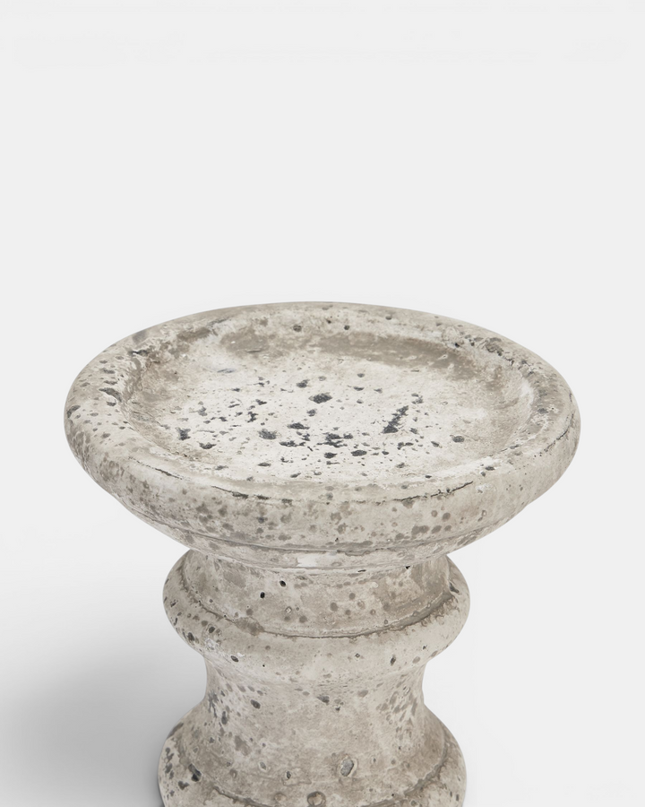 Beige candle holder with textured surface on a white background