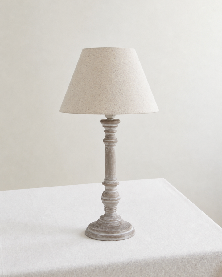 Table lamp with beige lampshade on white tablecloth