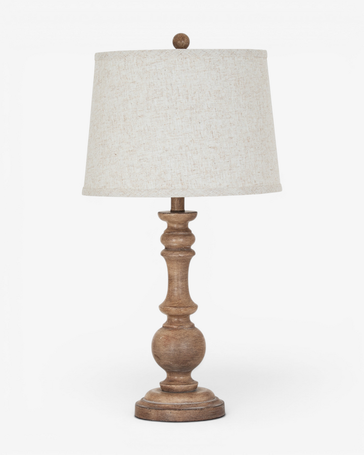 Table lamp with wooden base and beige lampshade on a white background