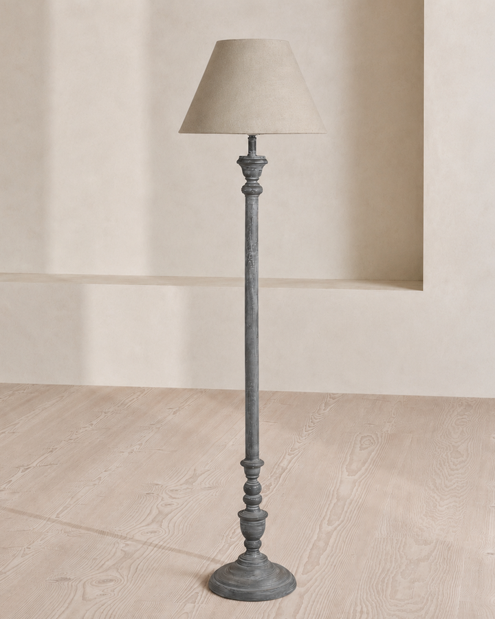 Floor lamp with a textured base and beige shade on a neutral background