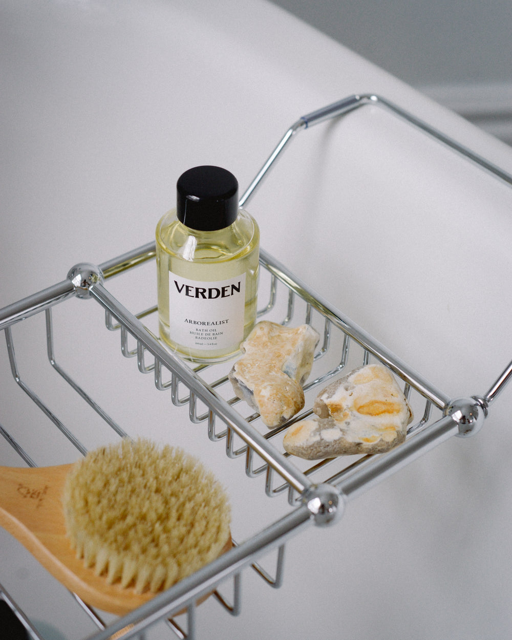 Bottle of Verden product on a metal shelf with a brush and soap.