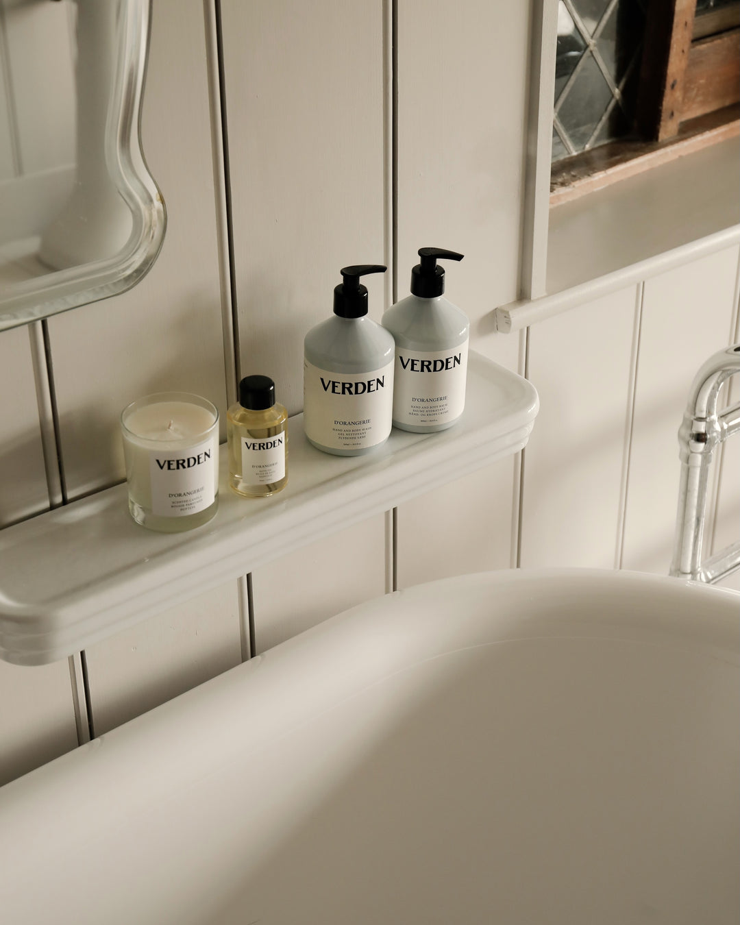Bathroom setting with Verden skincare products on a shelf above a bathtub.