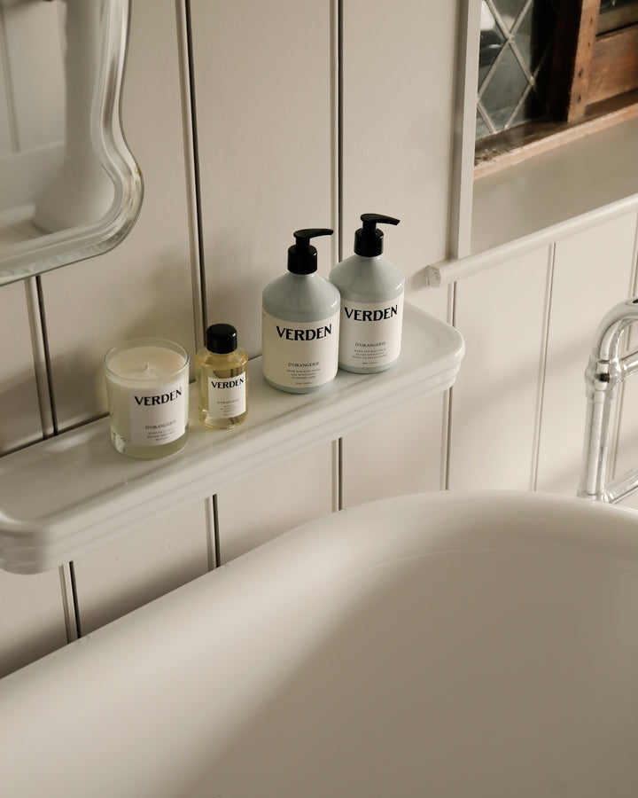 Bathroom setting with Verden skincare products on a shelf above a bathtub.