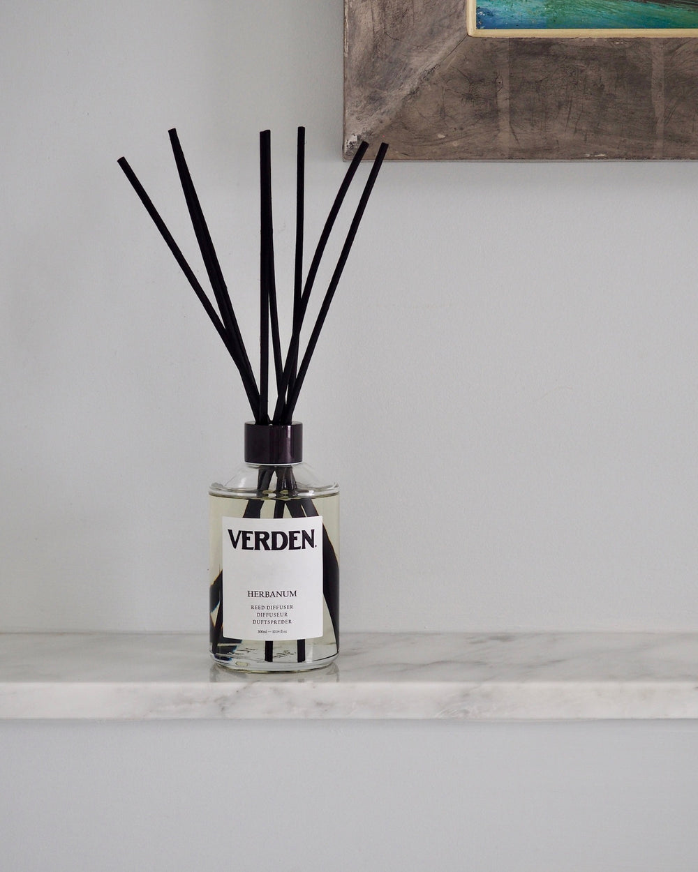 Diffuser with black sticks on a marble surface with a neutral background