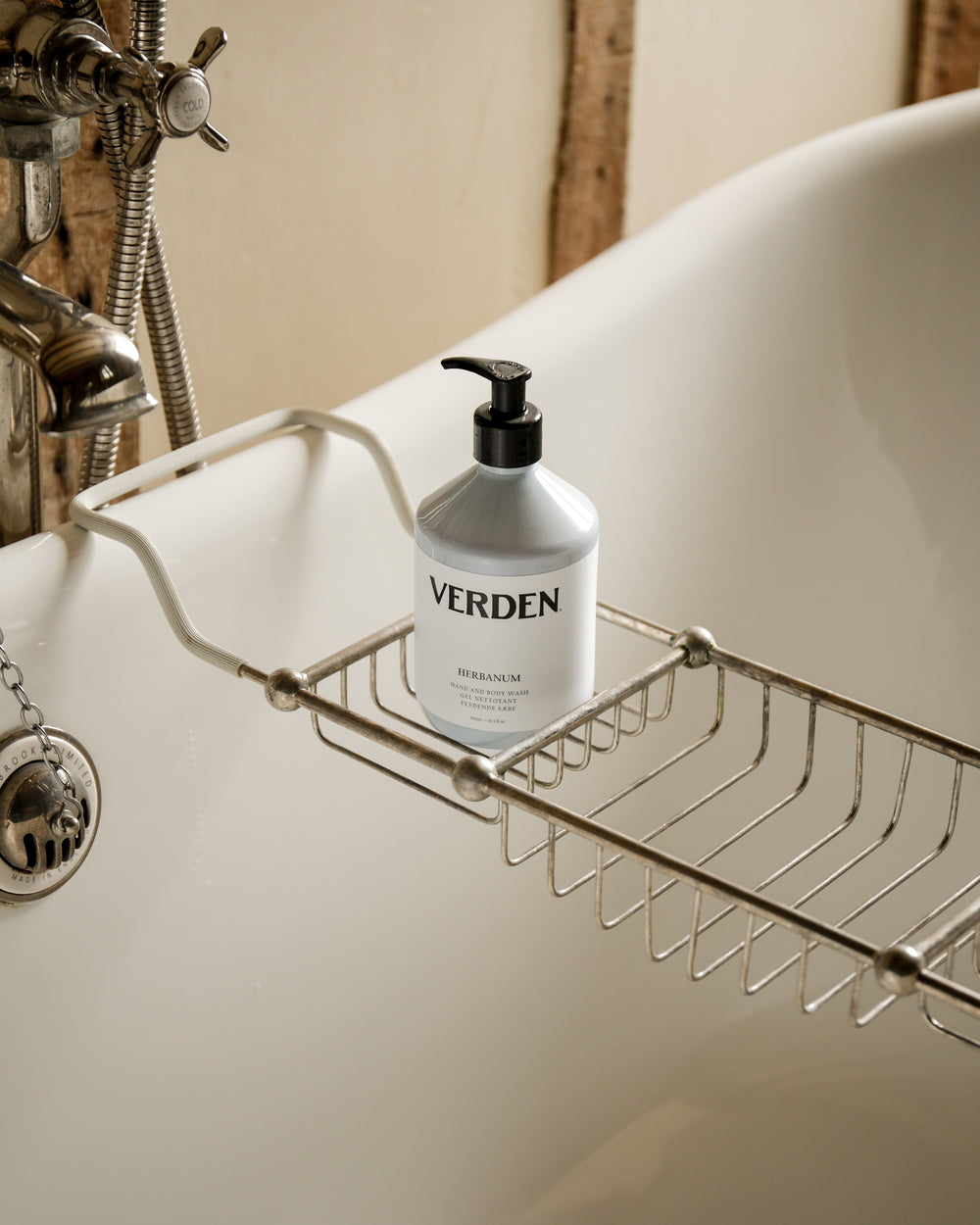 Verden soap dispenser on a metal soap dish over a bathtub.
