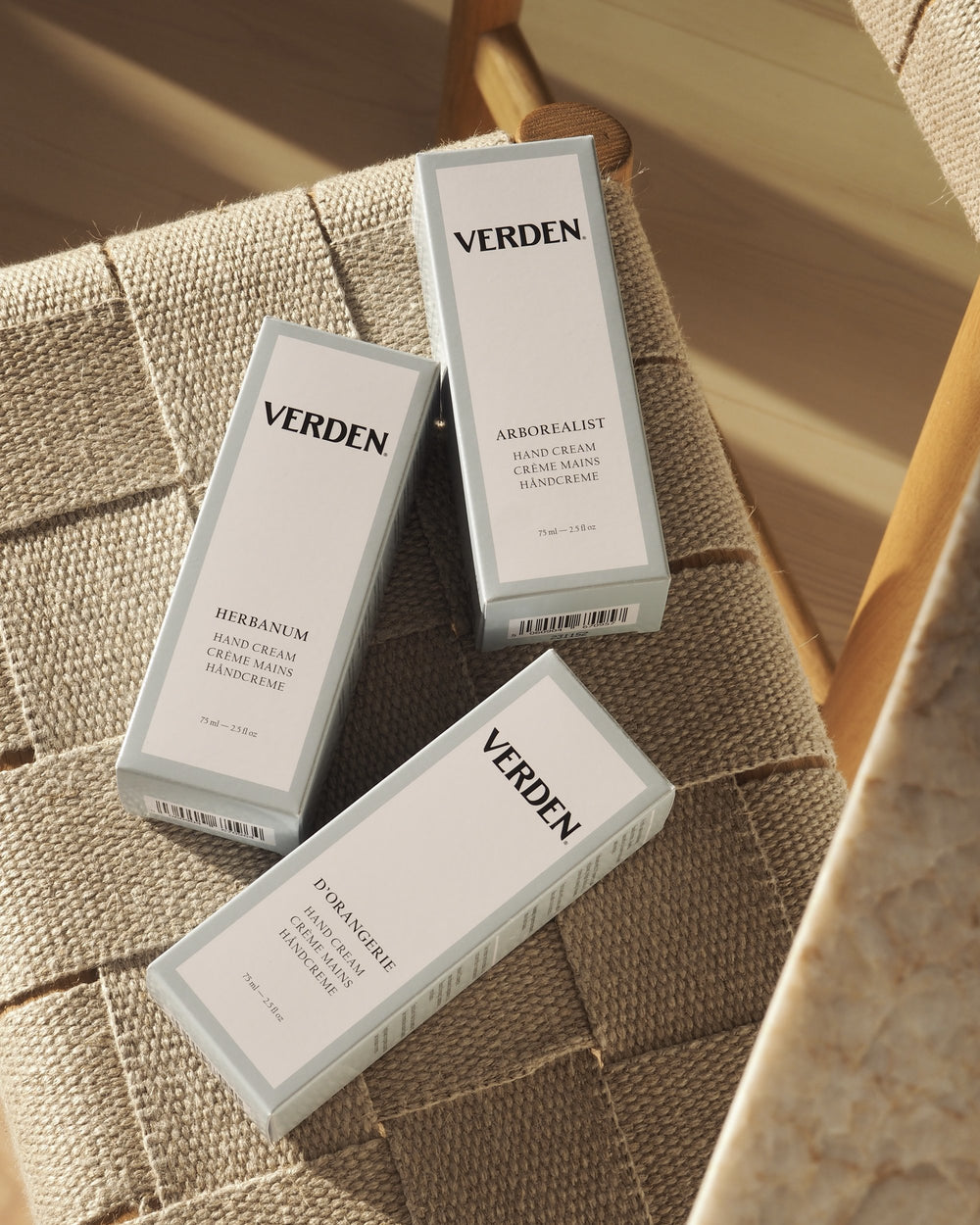 Three Verden hand cream products on a textured surface