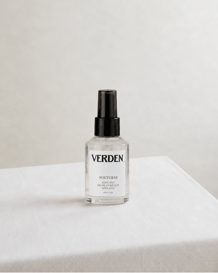 Clear bottle with black cap labeled 'VERDEN' on a white surface with a light gray background