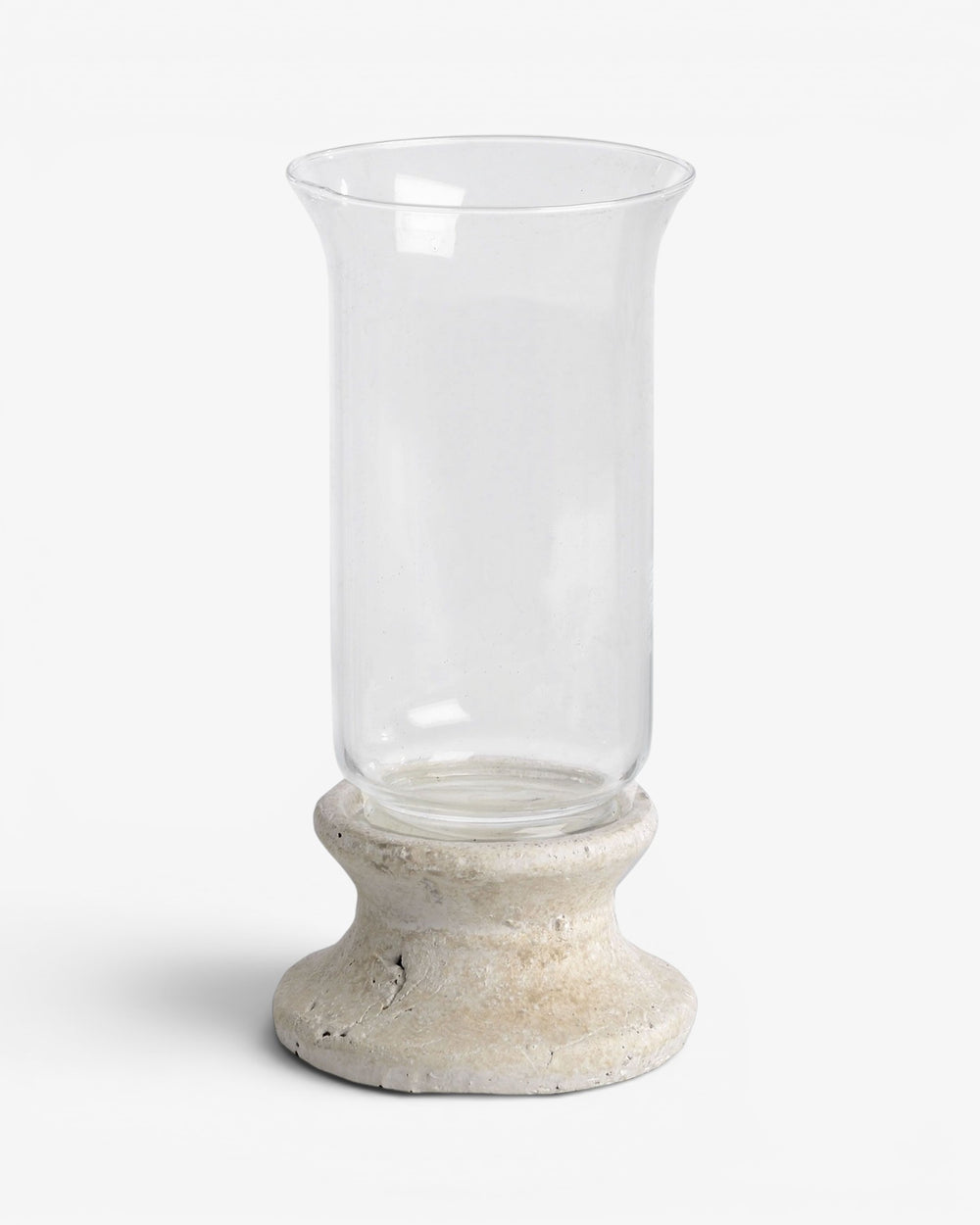 Clear glass candle holder with a stone-like base on a white background