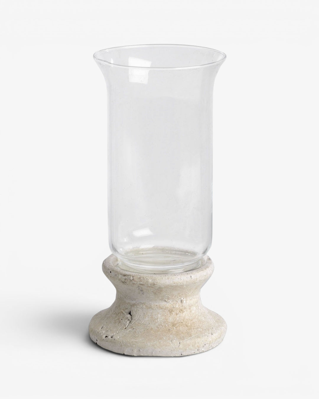 Clear glass candle holder with a stone-like base on a white background