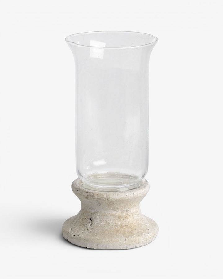 Clear glass candle holder with a stone-like base on a white background