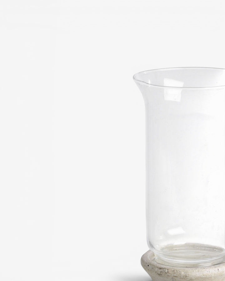 Clear glass candle holder on a light gray background