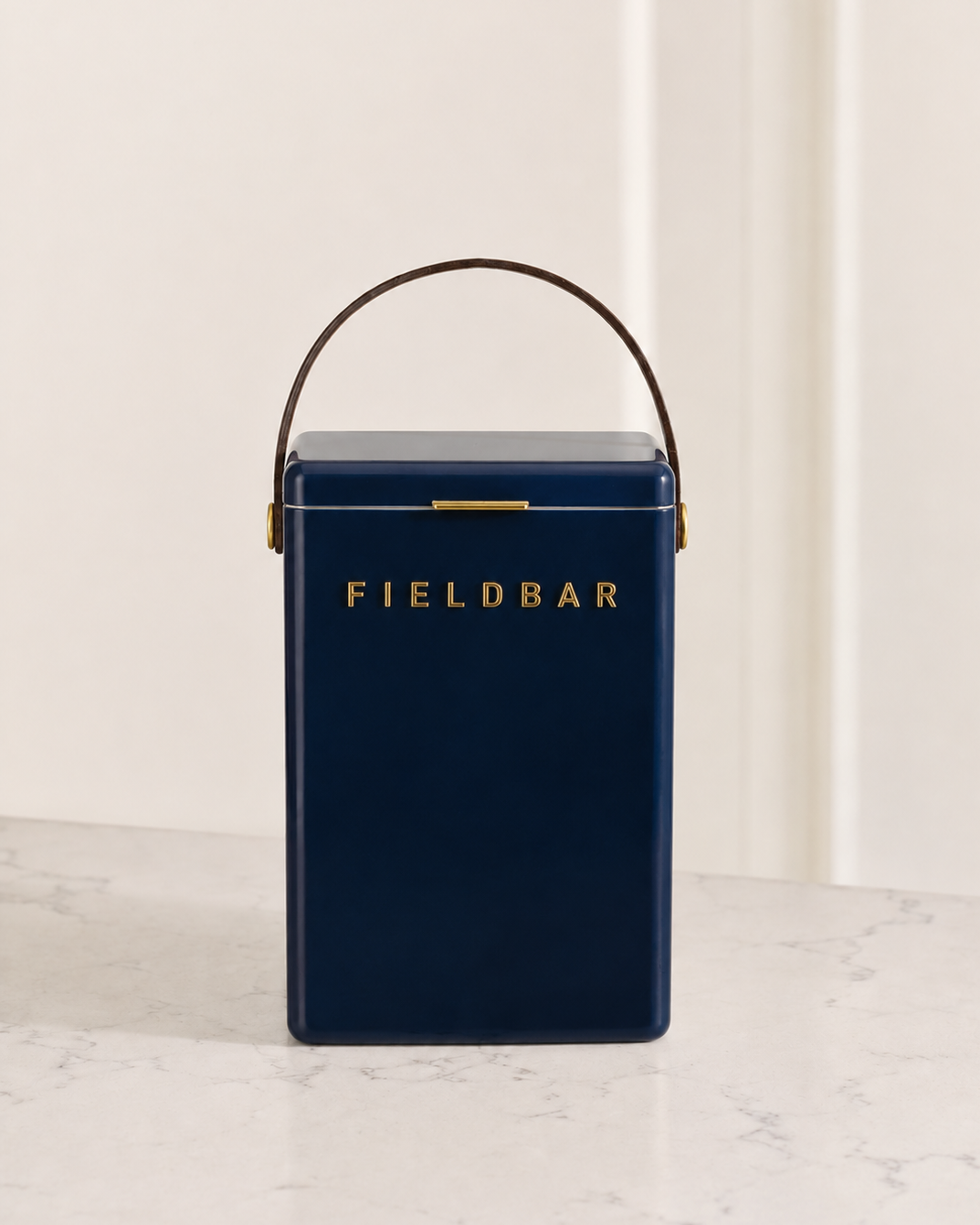 Navy blue cooler with 'FIELDBAR' branding on a marble surface.
