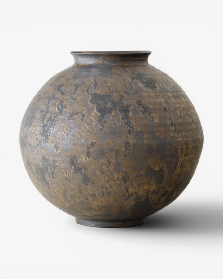 Bronze vase with textured surface on a white background
