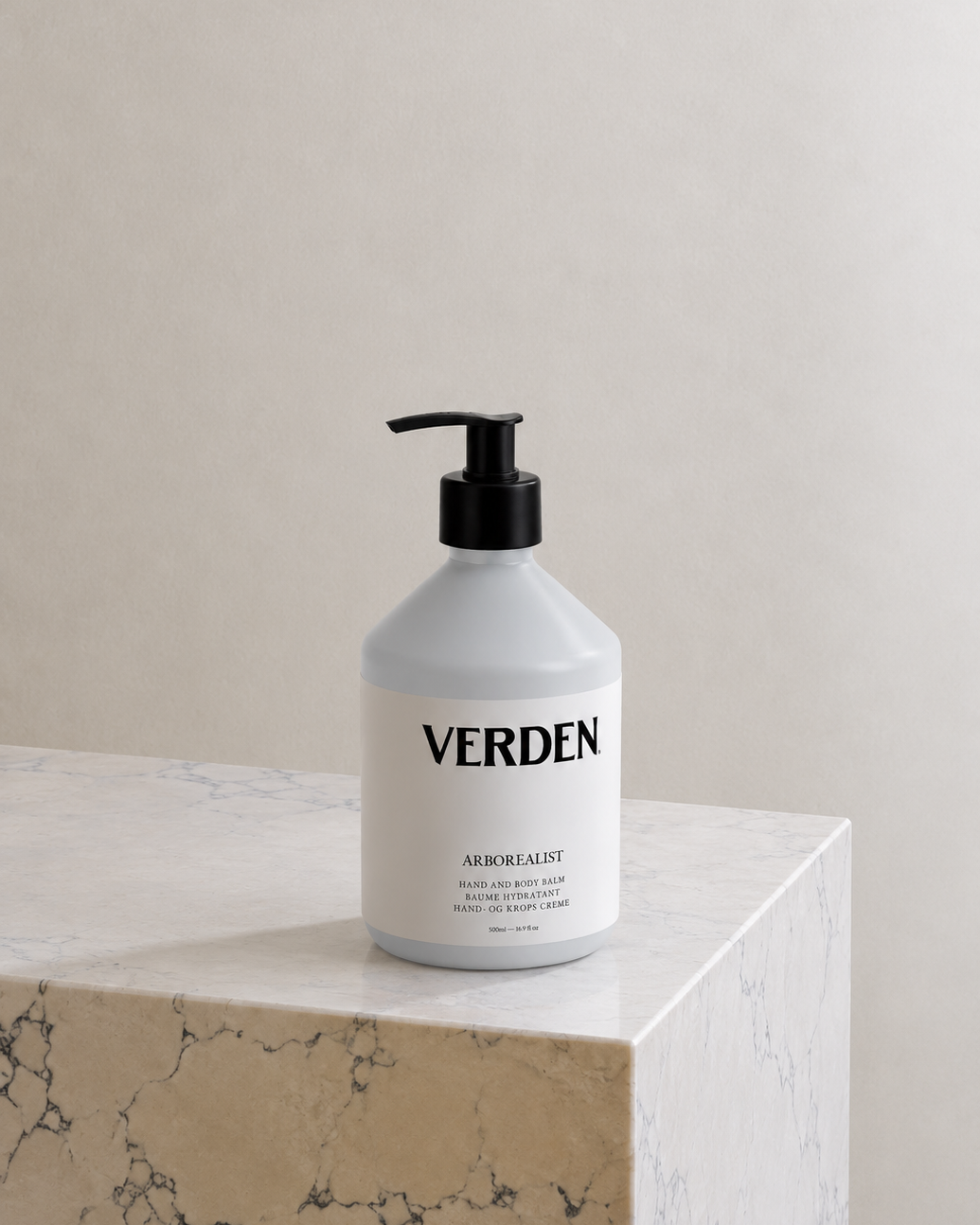 White bottle with black pump labeled 'VERDEN' on a marble surface with a neutral background