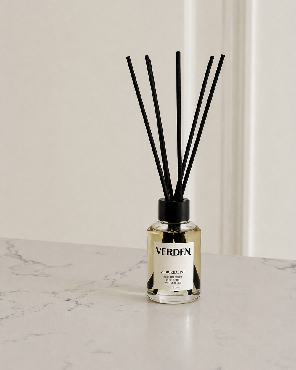 Diffuser bottle with black sticks on a marble surface