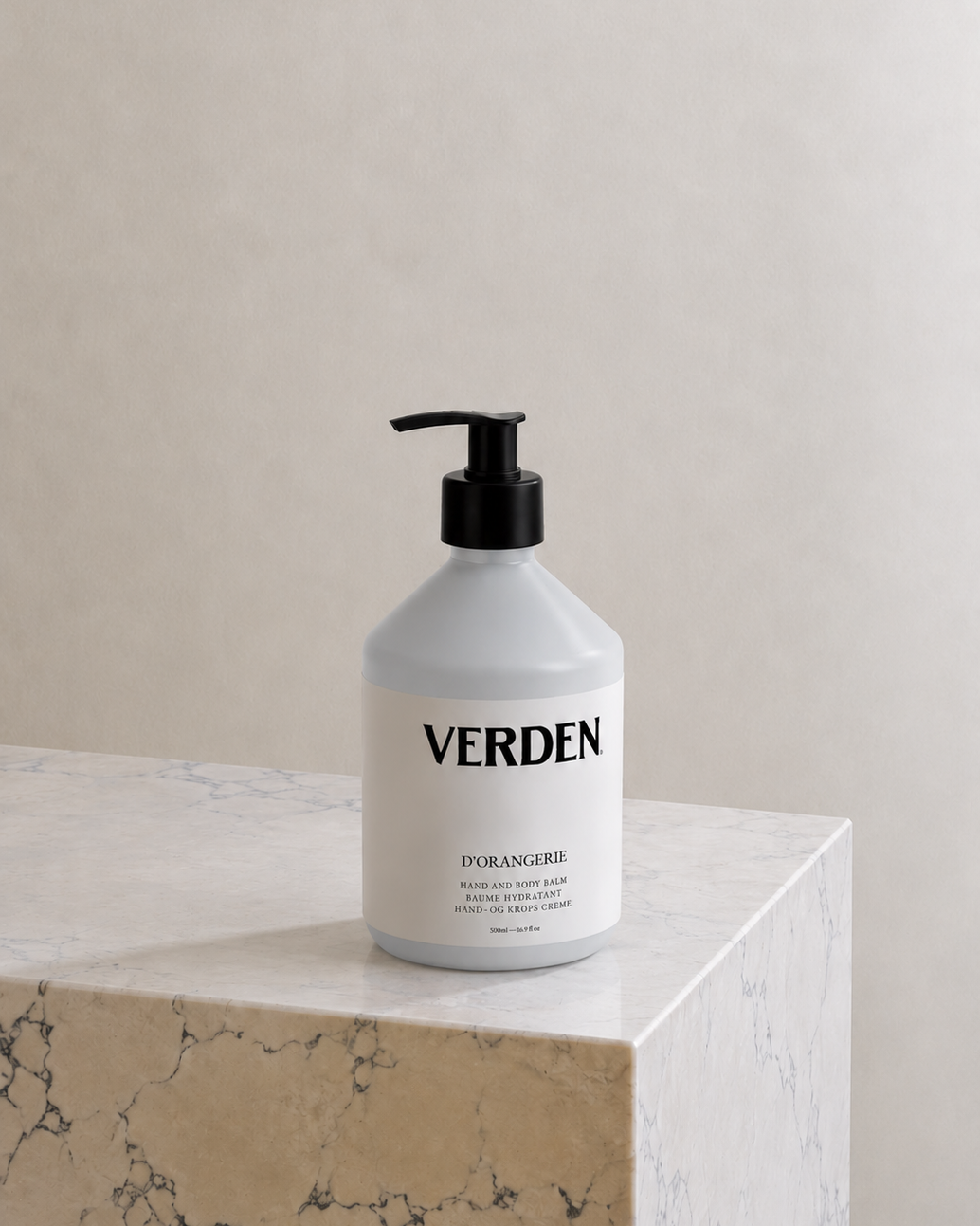 White bottle with black pump labeled 'VERDEN' on a marble surface with a neutral background