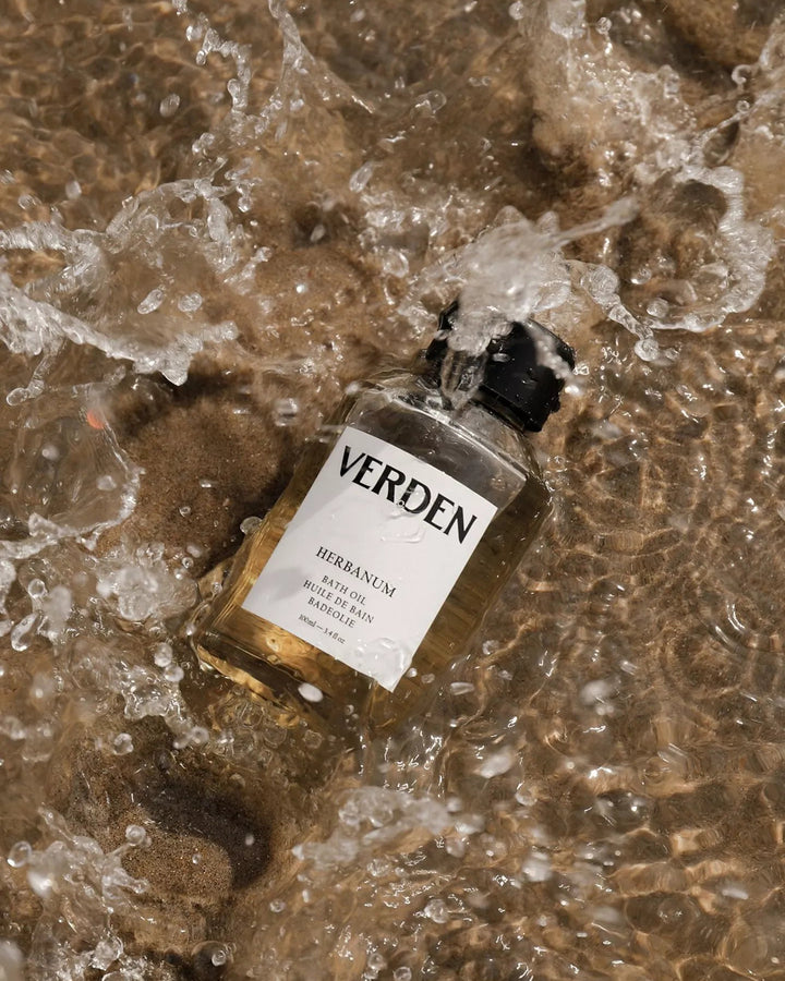 Verden bath oil bottle on wet sand with water droplets