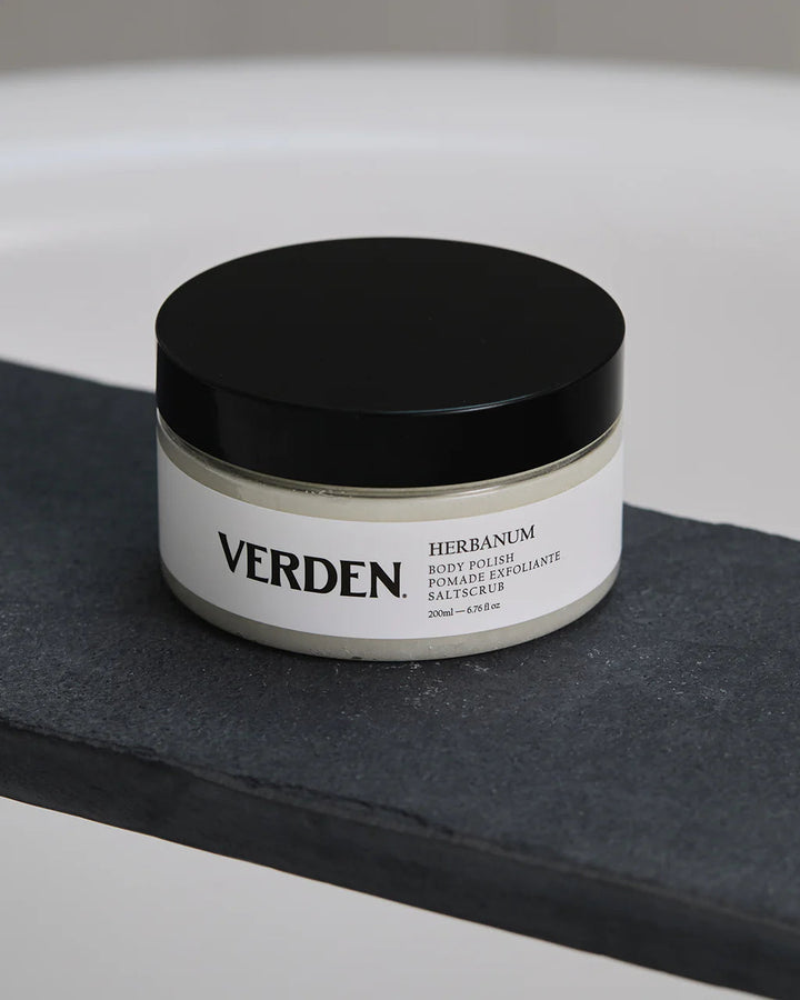 Verden herbanum body polish jar on a black surface