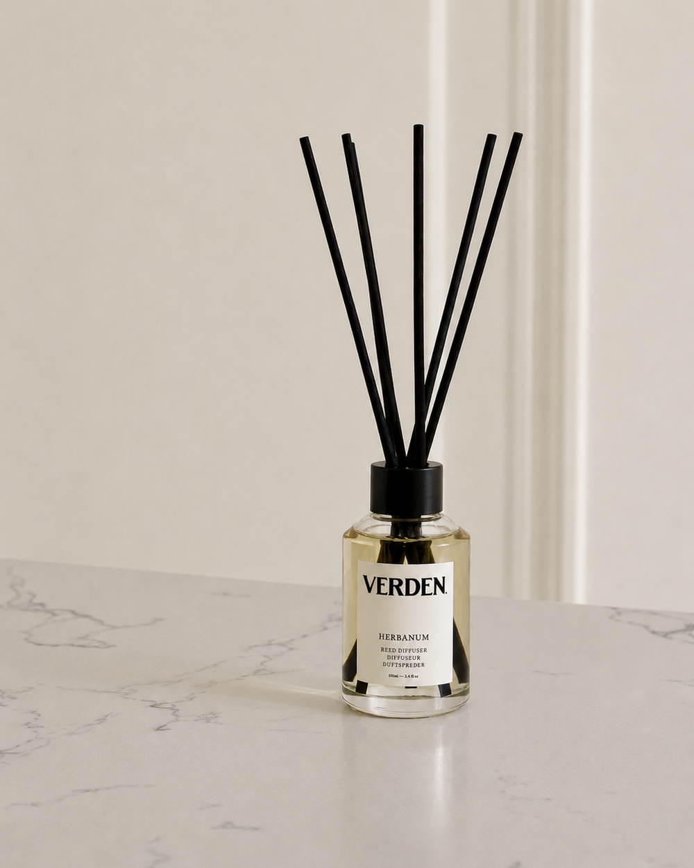 Verden diffuser bottle with black sticks on a marble surface