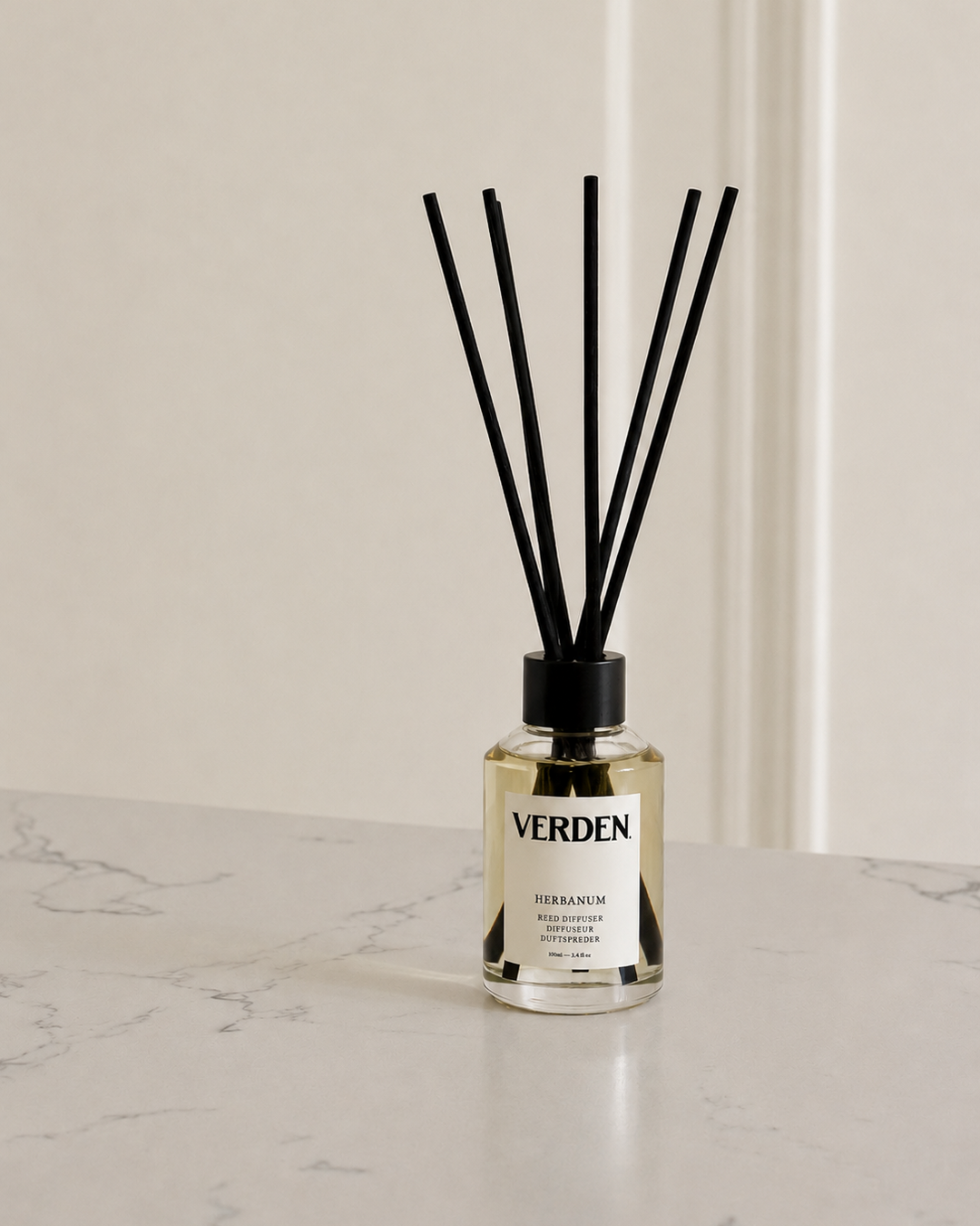 Verden diffuser bottle with black sticks on a marble surface