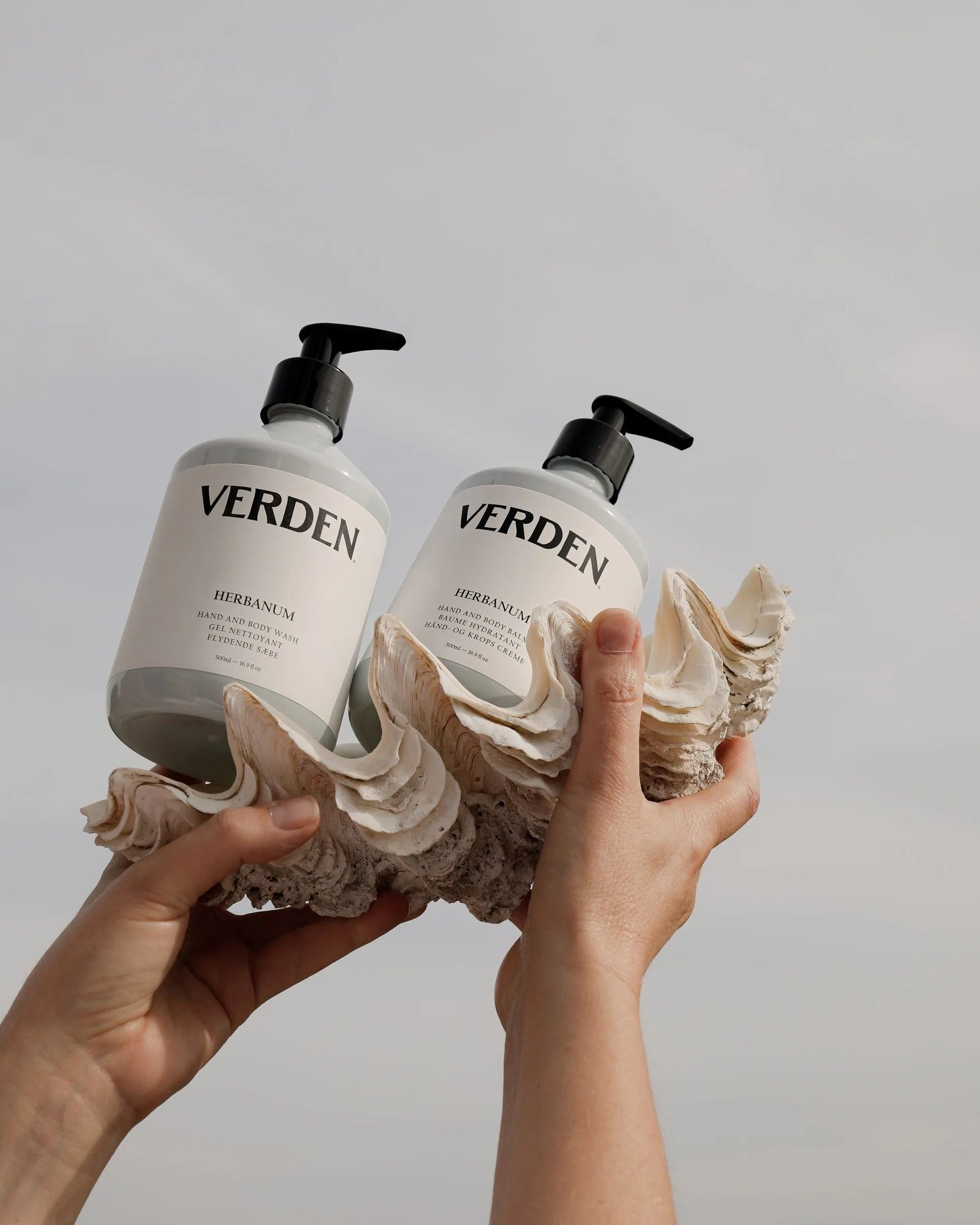 Two 'VERDEN' bottles held by a person against a plain background